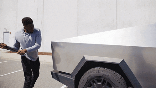 a man in a grey hoodie is pushing a silver truck