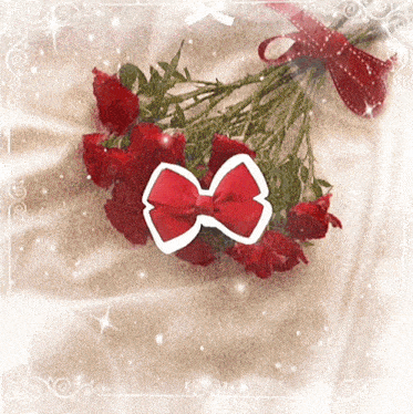 a bouquet of red roses with a red bow in the middle
