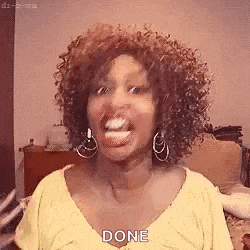 a woman with curly hair is making a funny face and sticking out her tongue while wearing a yellow shirt .