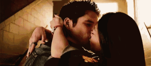 a man and a woman are kissing and hugging each other .
