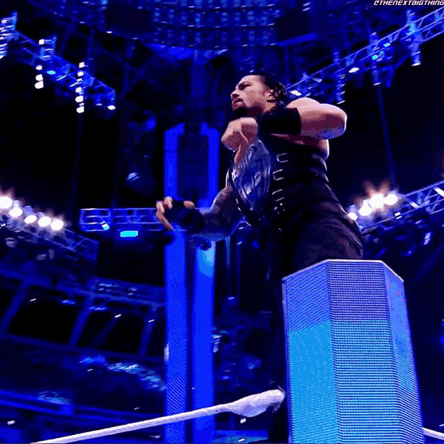 a wrestler is jumping over a rope in front of a wrestlemania sign