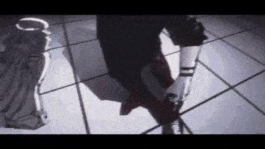 a person is standing on a tiled floor in a dark room holding a gun .