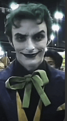 a man in a joker costume has a green bow tie