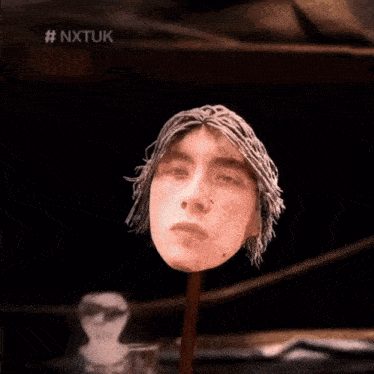 a person 's head is behind a glass with the hashtag nxtuk on the bottom