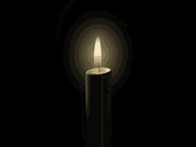 a candle with a picture of a man on it is lit up