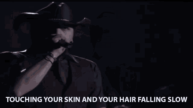 a man singing into a microphone with the words touching your skin and your hair falling slow