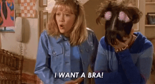 two girls are standing next to each other and one of them is saying `` i want a bra ! ''