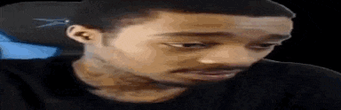 a man with a beard is sitting in a chair and making a face .