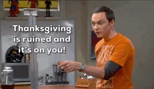 a man in an orange shirt is standing in front of a white board that says thanksgiving is ruined and it 's on you !