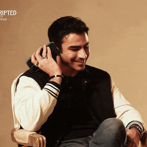 a man sitting in a chair talking on a cell phone with the word ripped in the corner
