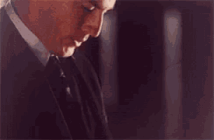 a man wearing a suit and tie looks at the camera