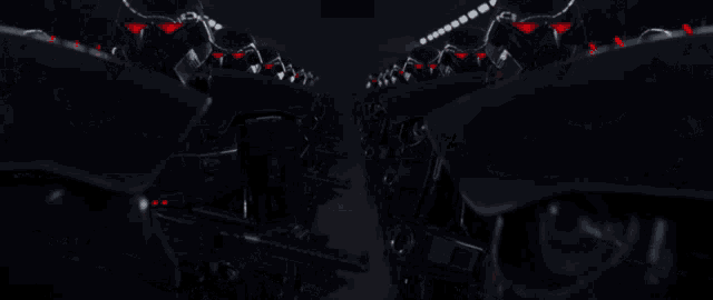 a row of black robots with red lights on them