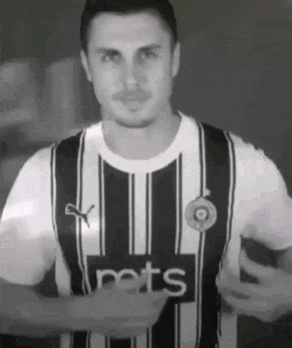 a man wearing a black and white striped shirt with the word pets on it .