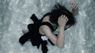 a woman in a maid outfit is laying on a plastic sheet