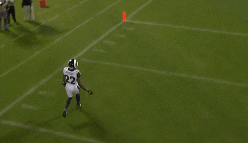 a football player is doing a handstand on a field with a sign that says play on it