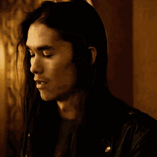 a close up of a man with long hair