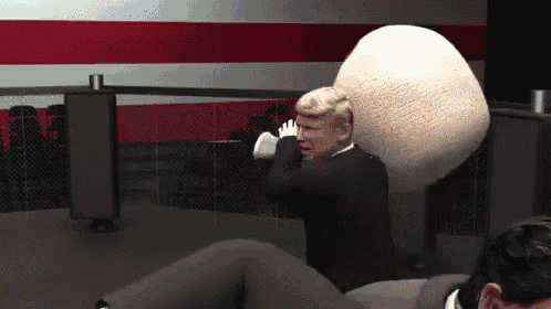 a man in a suit is being hit by a large ball