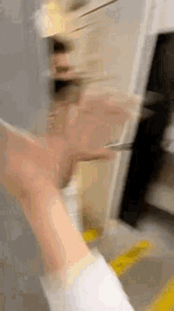 a blurry picture of a person 's hand holding a knife in a kitchen .
