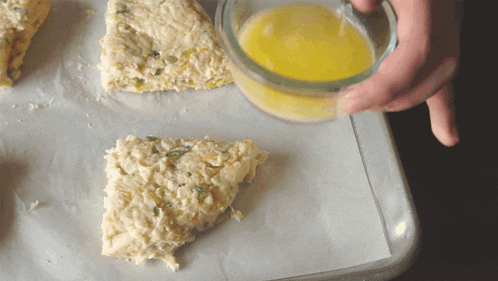a person pouring a liquid into a triangle shaped pastry