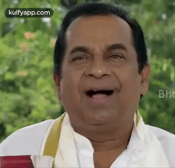 a man is making a funny face with his mouth open while holding a glass of water .
