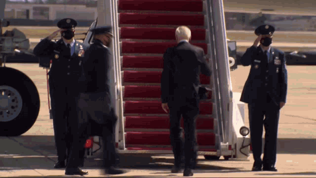 a man in a suit is walking towards a plane