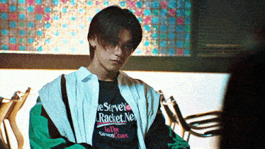 a young man wearing a t-shirt that says ' racket net ' on it