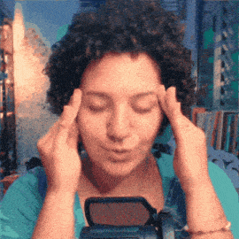 a woman with curly hair has her eyes closed and her hands on her forehead