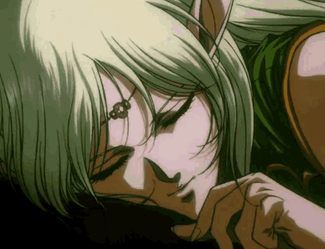 a woman with green hair and a necklace on her forehead is laying down with her eyes closed