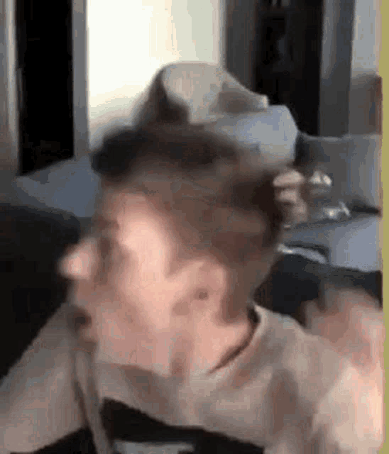 a man is making a funny face while sitting on a couch in a living room .