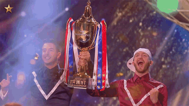 a man holds up a trophy that says the champions on it