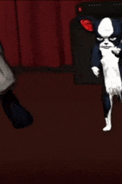 a black and white cat is dancing in front of a red curtain .