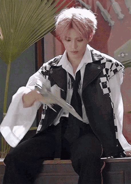 a man with pink hair wearing a black and white jacket and tie