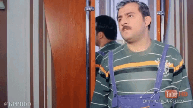 a man with a mustache is standing in front of a mirror with a youtube logo on the bottom