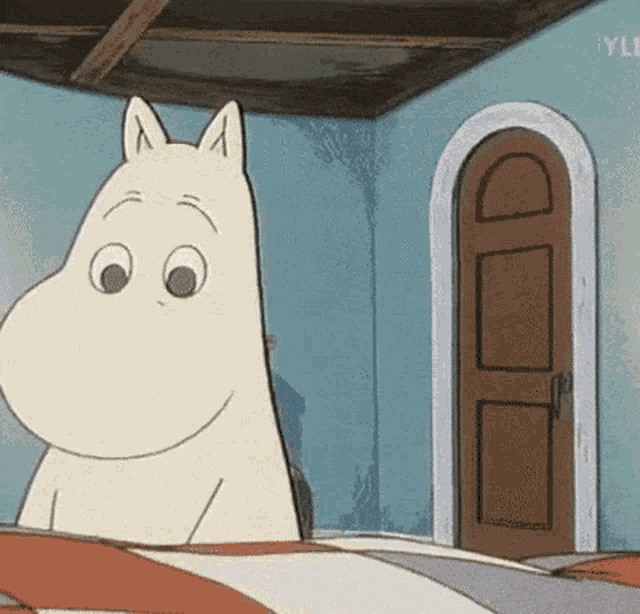 a cartoon character is sitting on a bed in a room with a door in the background .