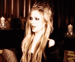 a blonde woman wearing a crown and a black dress