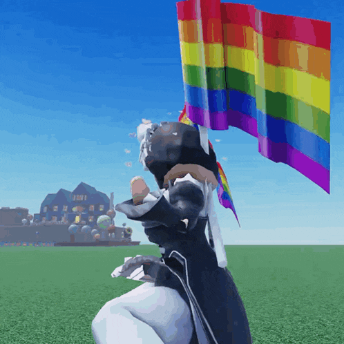 a person is holding a rainbow flag in a field