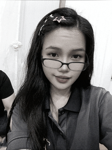 a woman wearing glasses and a hair clip has a star in her hair