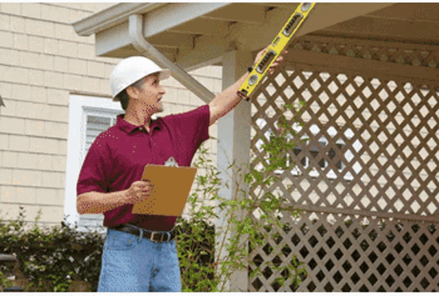 a man in a hard hat is holding a yellow level