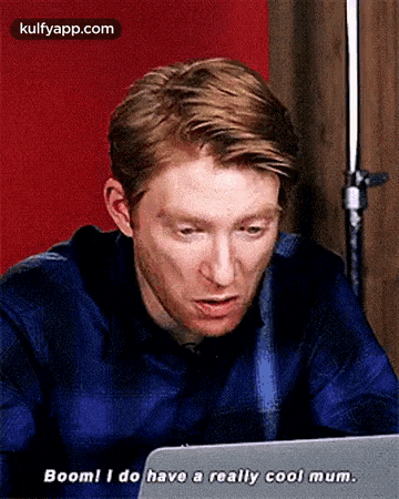 a man is sitting in front of a laptop computer and saying `` boom ! i do have a really cool mum '' .