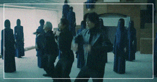 a group of people in blue robes are dancing together