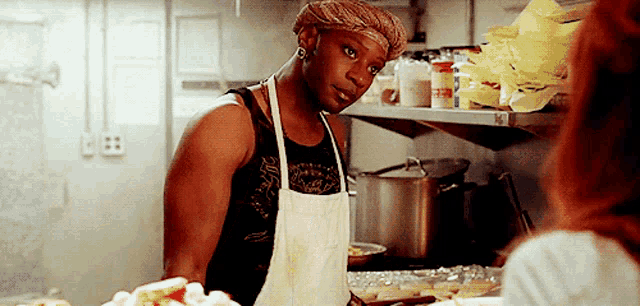 a man wearing a chef 's cap and apron is standing in a kitchen