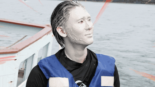 a man with white paint on his face is wearing a blue life vest