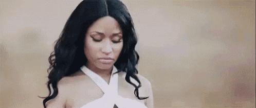 a woman with long black hair is wearing a white dress and making a sad face .