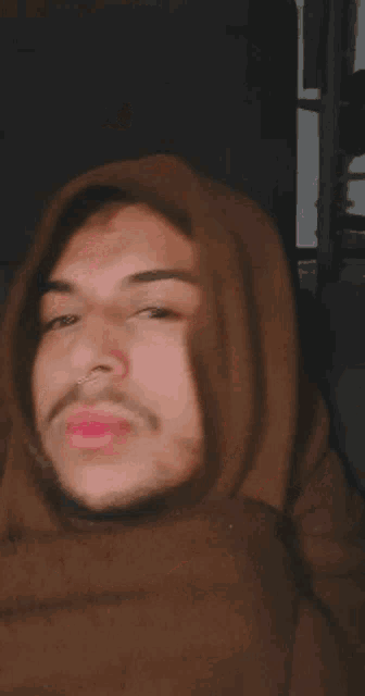 a close up of a person 's face with a pink lip and nose ring