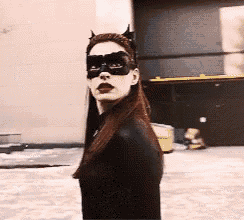 a woman in a catwoman costume is walking down a street