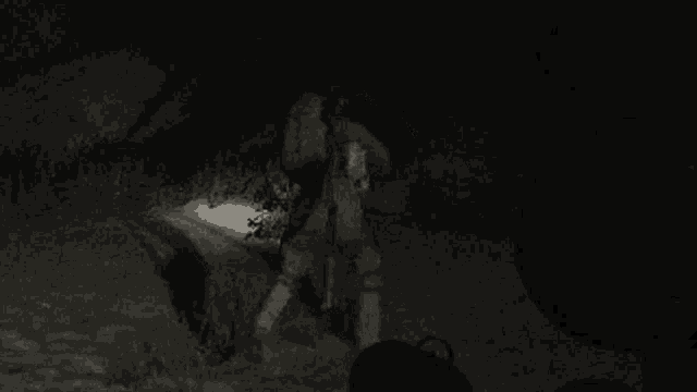 a black and white photo of a soldier with a backpack holding a gun .