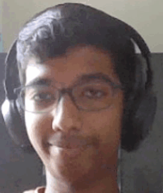 a close up of a young man wearing headphones and glasses .