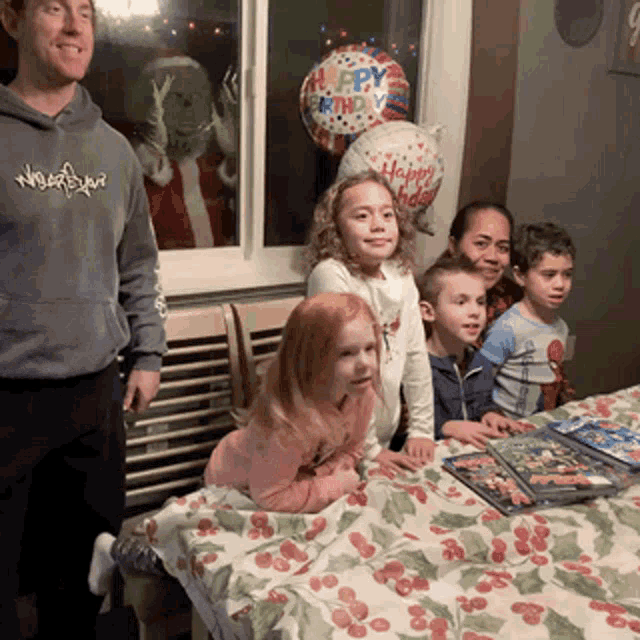 a group of children sitting at a table with a grinch behind them