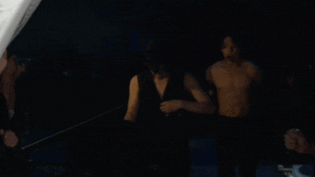 a man without a shirt is standing next to another man