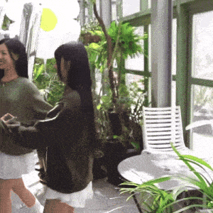a woman in a green sweater is standing next to another woman in a white skirt